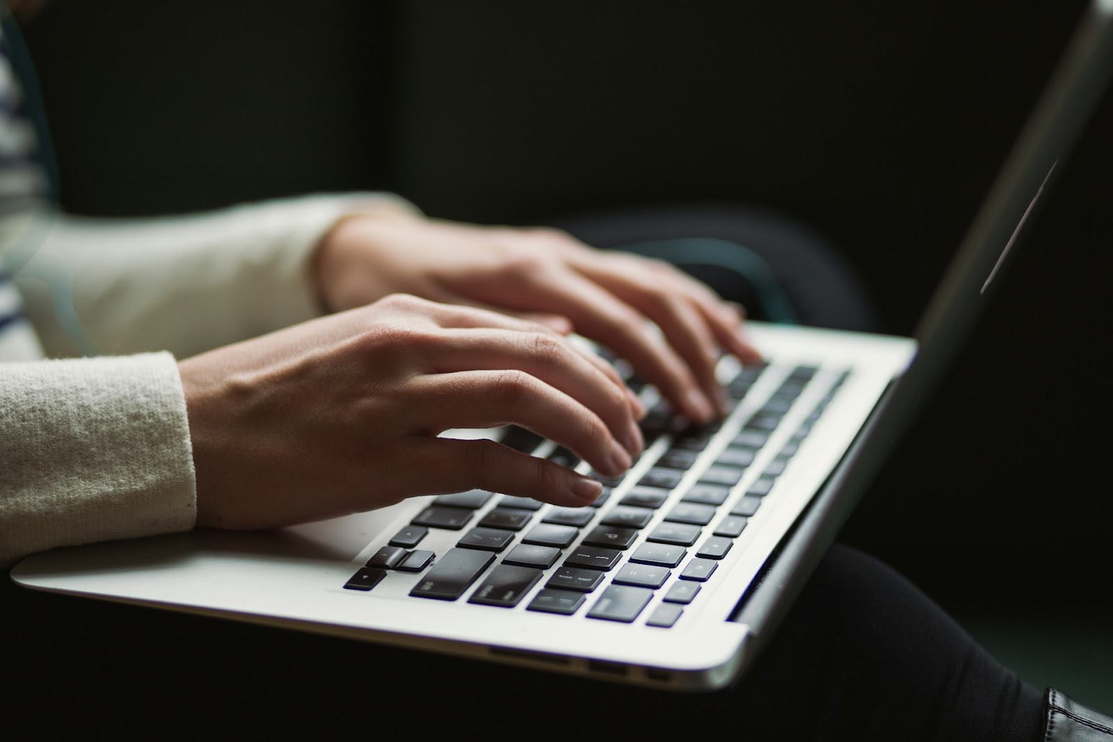 A person's hands on a laptop keyboard