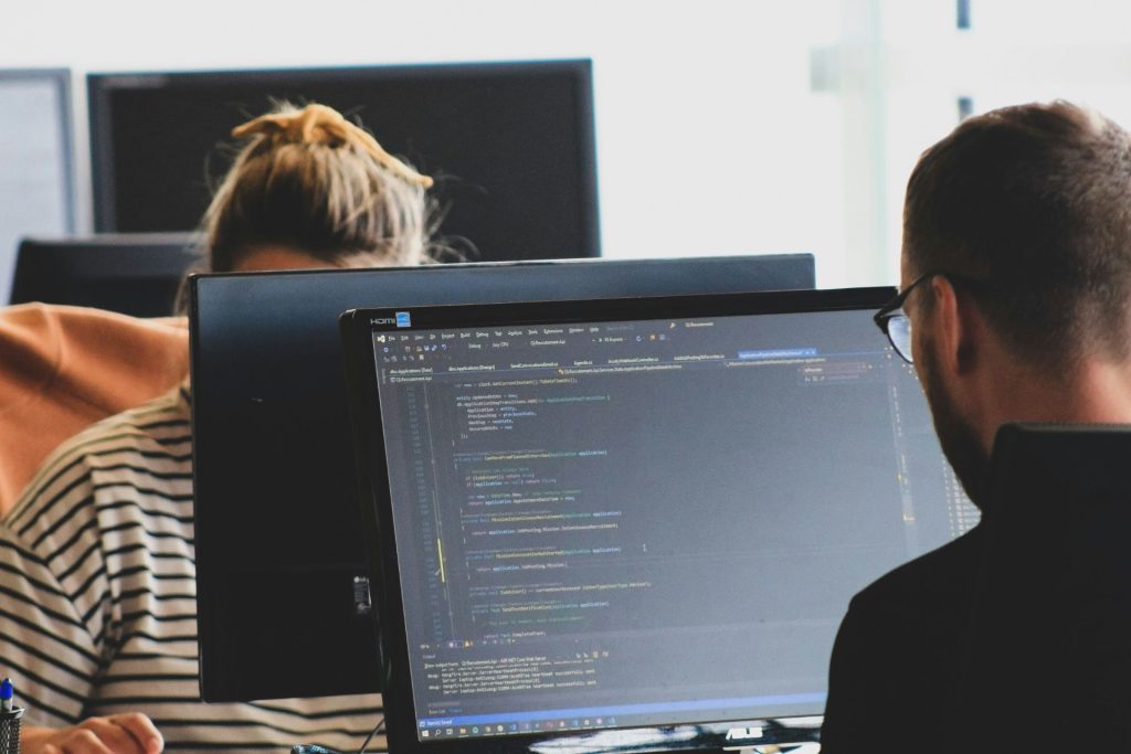 Two colleagues focused on their computer screens.