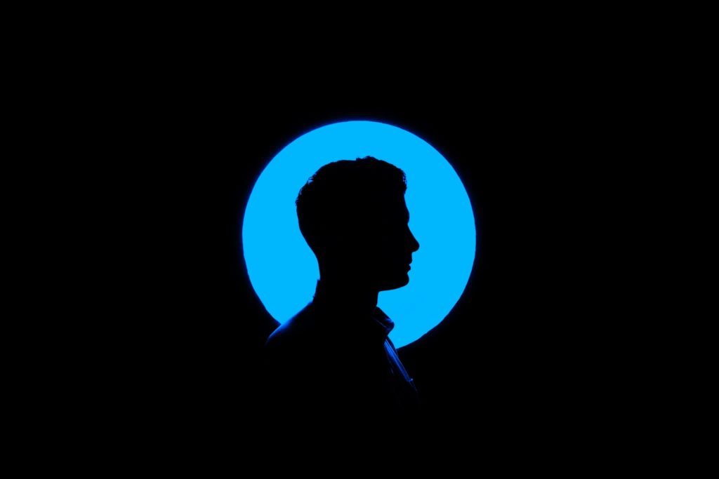 silhouette of a man against a round blue background