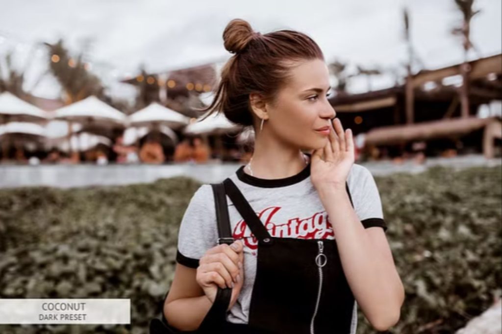 A woman wearing a graphic t-shirt and black overalls