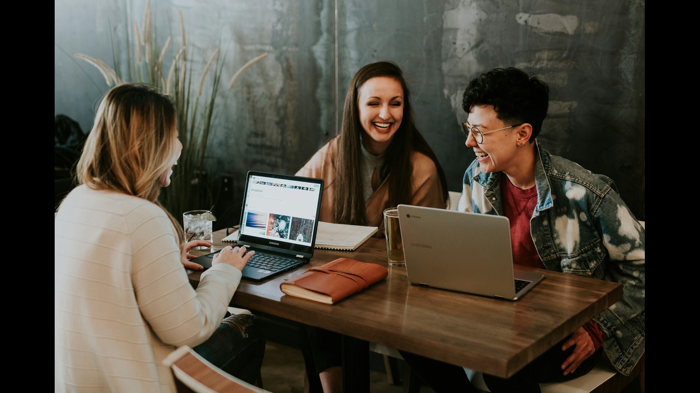 people on their laptop laughing together