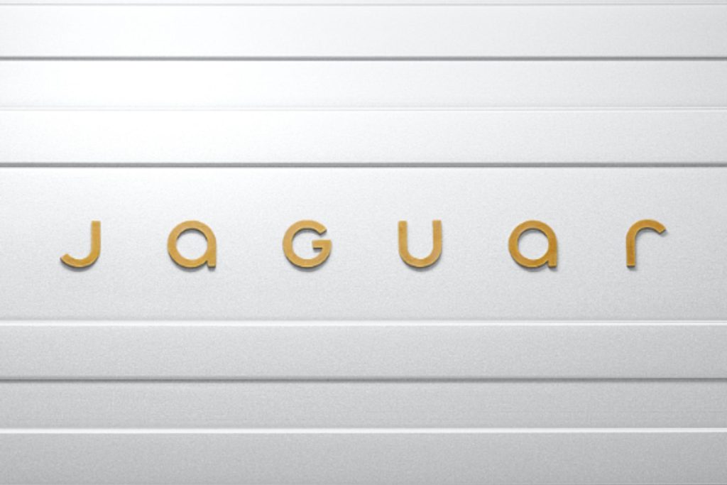 Jaguar's new logo featuring a slim wordmark in gold against a neutral background.