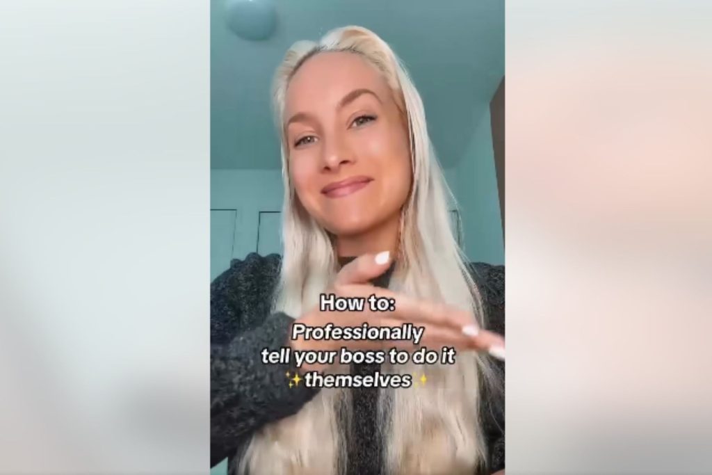 A woman with long blonde hair smiles as she takes a short form video of herself.