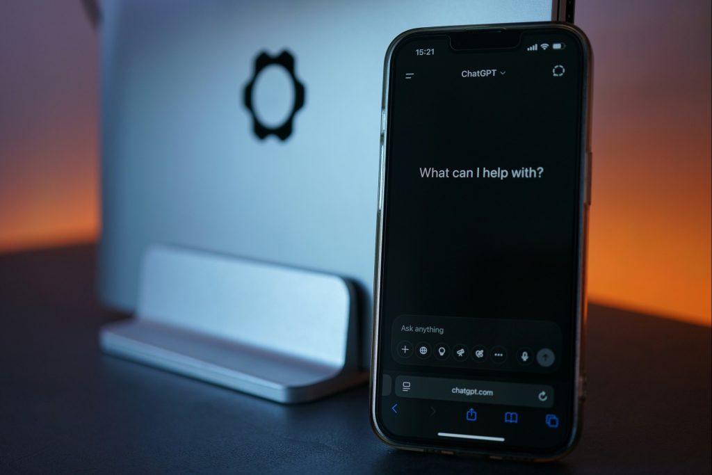 cellphone featuring a chatbot while standing against a tablet