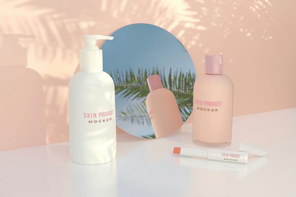 A mockup of a lotion bottles sitting against a mirror and a pink backdrop