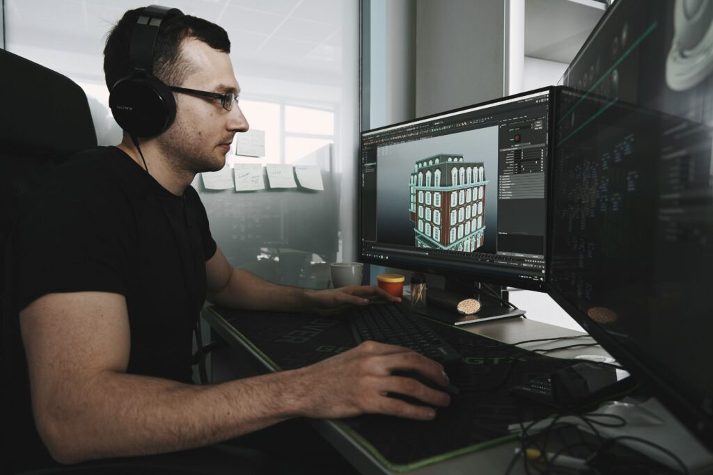 Designer using 3D modeling software on a desktop computer to create a building model