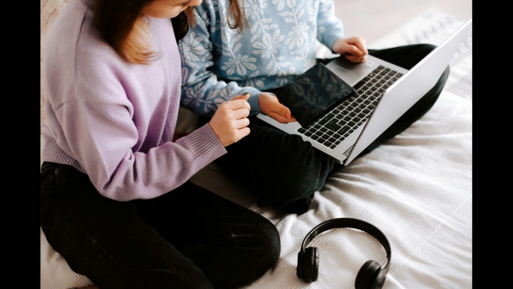 photo of two kids using the laptop
