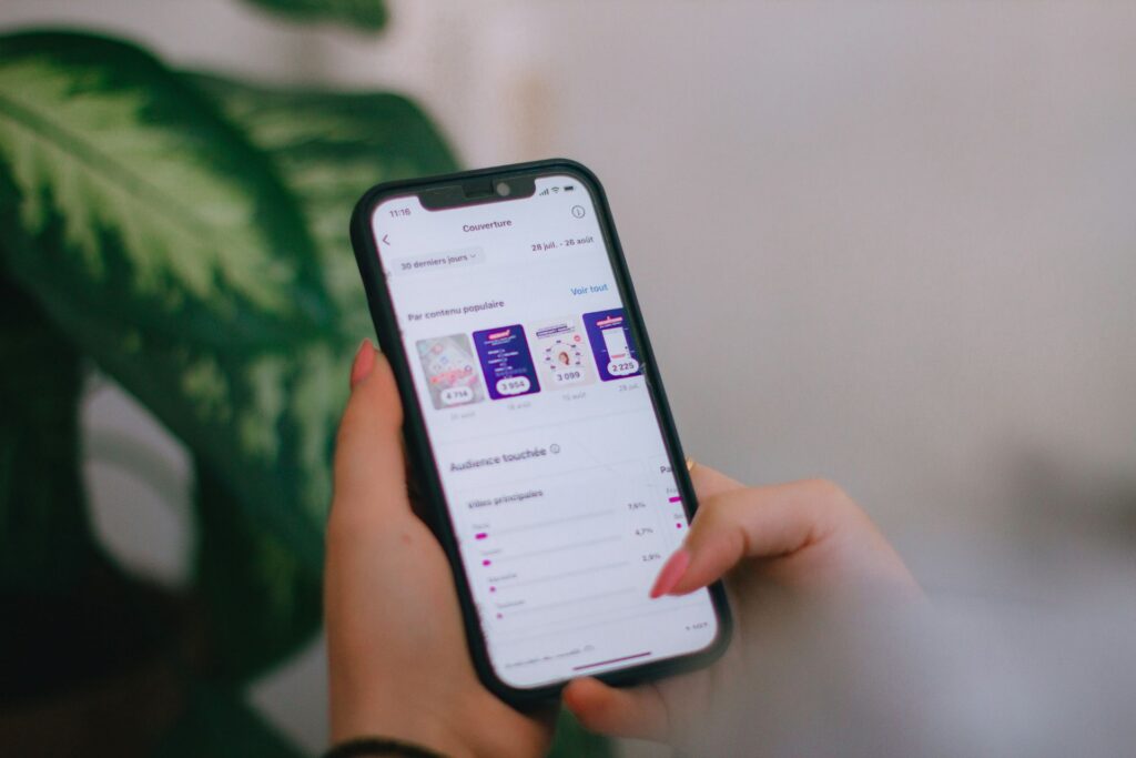 Person holding and scrolling through a social media analytics dashboard