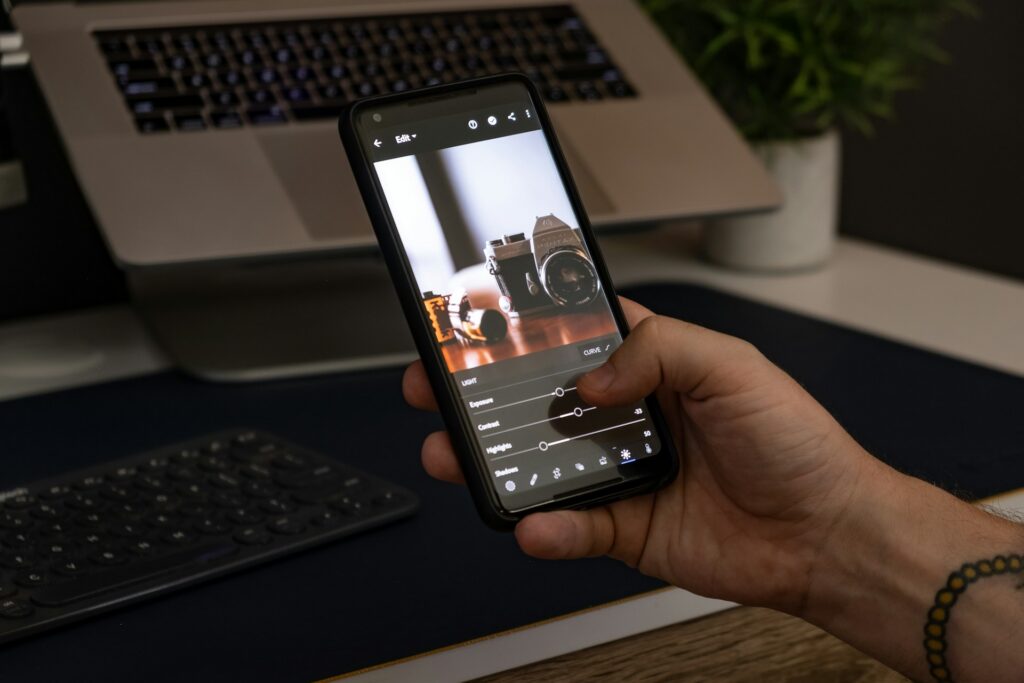 person holding smartphone editing a photo on photo editing app