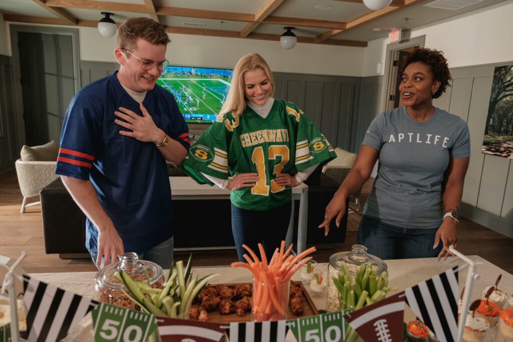 Friends watching Super Bowl.

Image link: https://unsplash.com/photos/friends-in-football-jerseys-gather-around-a-snack-table-vsQ8cJYJI_o