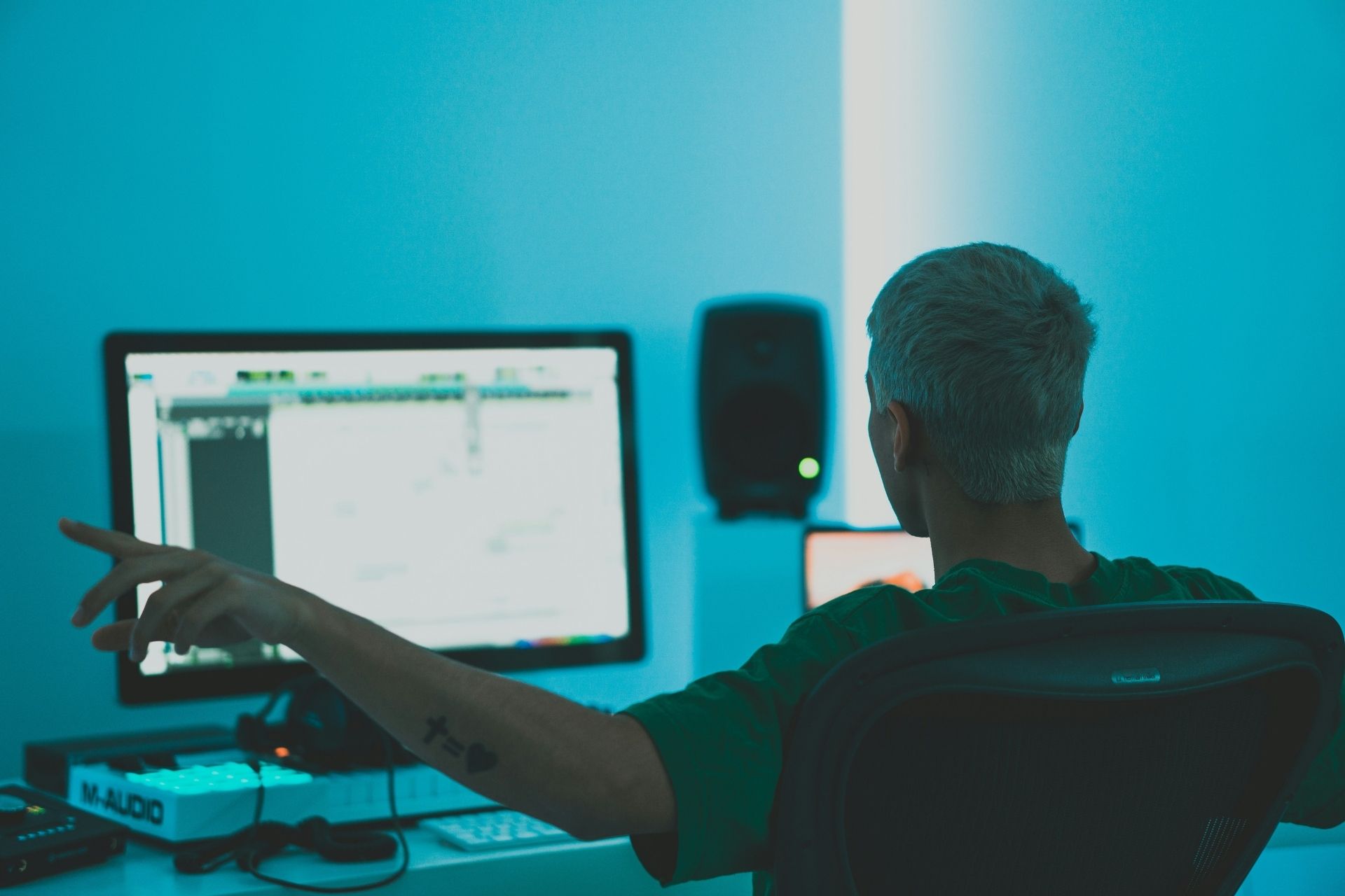 Person working at a desktop computer in a blue-lit office