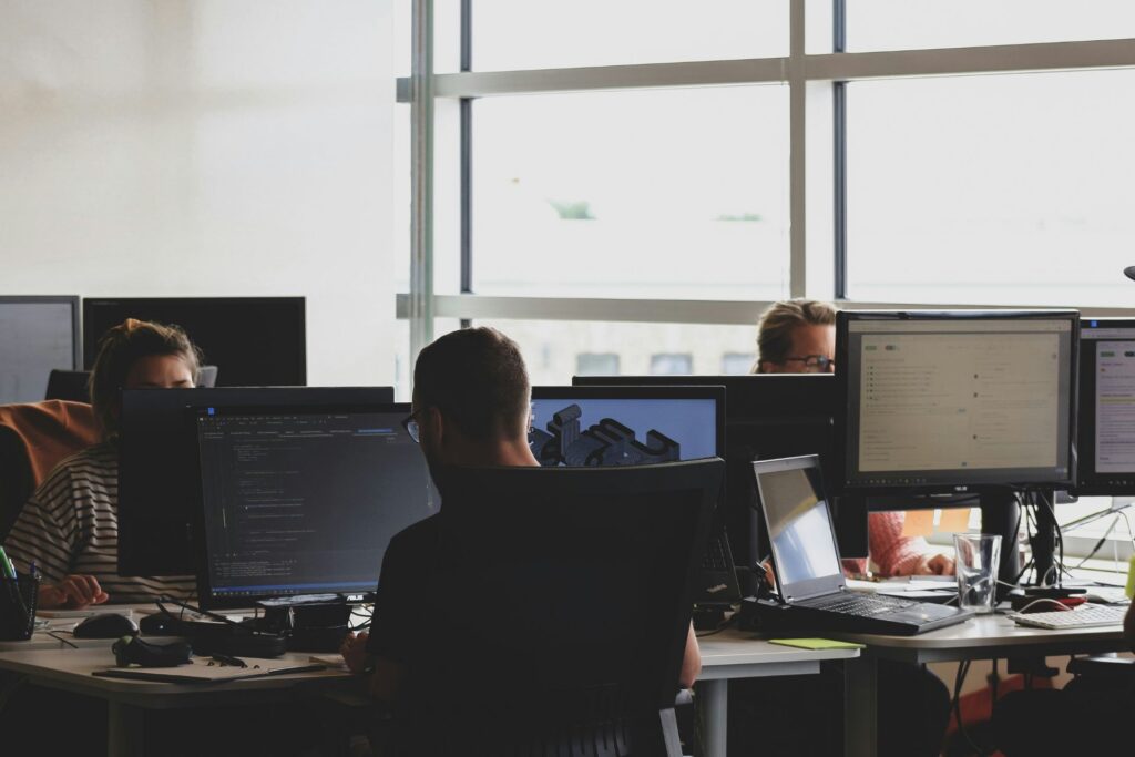 Design and development team working at multiple computer monitors