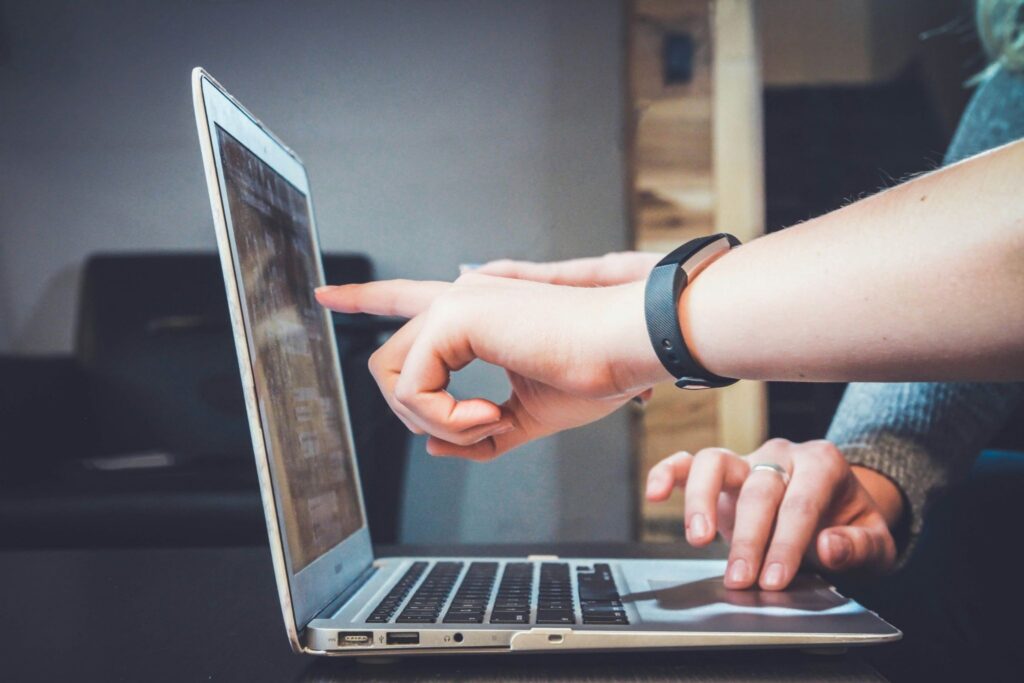Individuals choosing WordPress templates on a laptop.