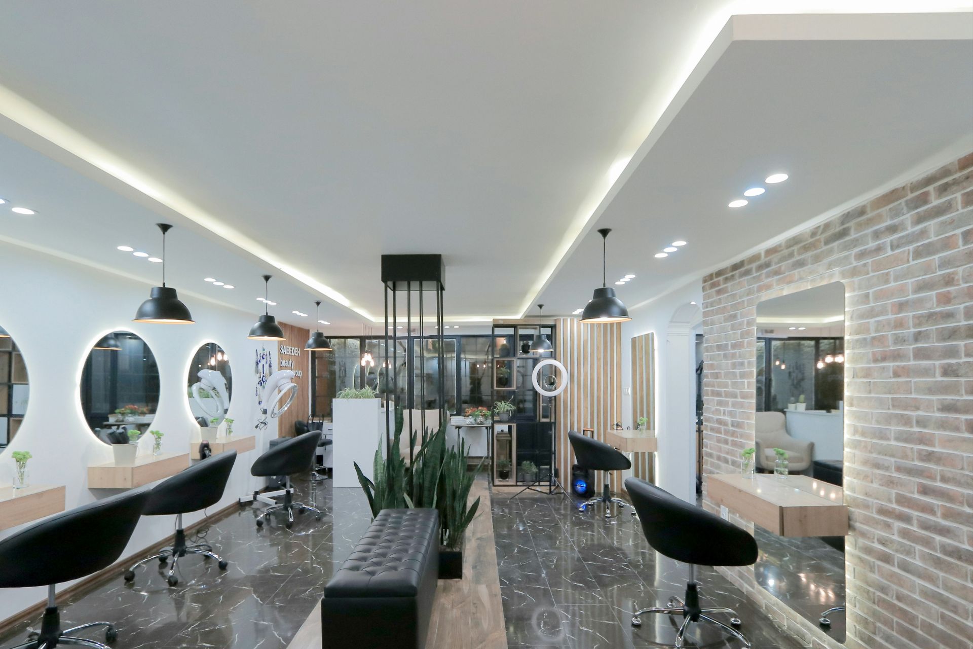 Modern luxury hair salon with black styling chairs, round mirrors and sleek lighting