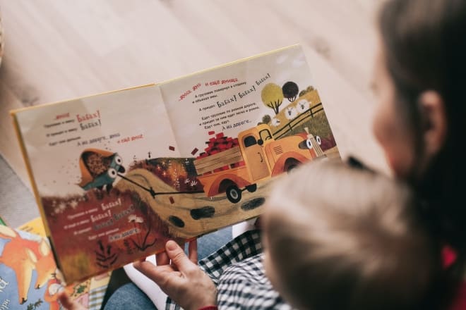 woman reading a book to a child