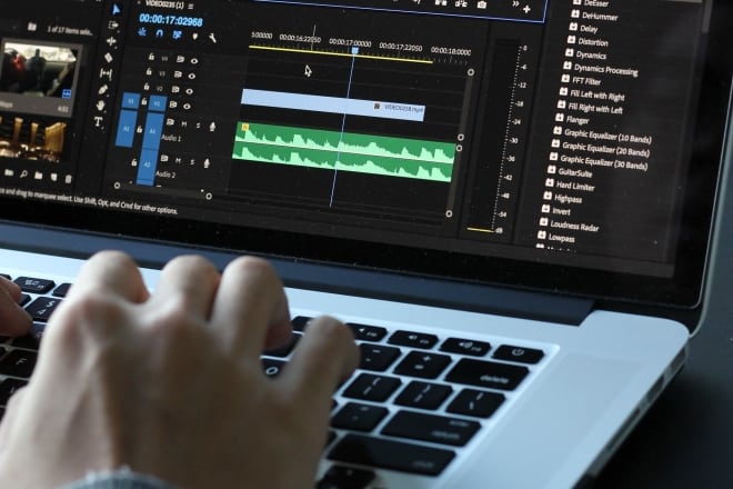person editing video on laptop