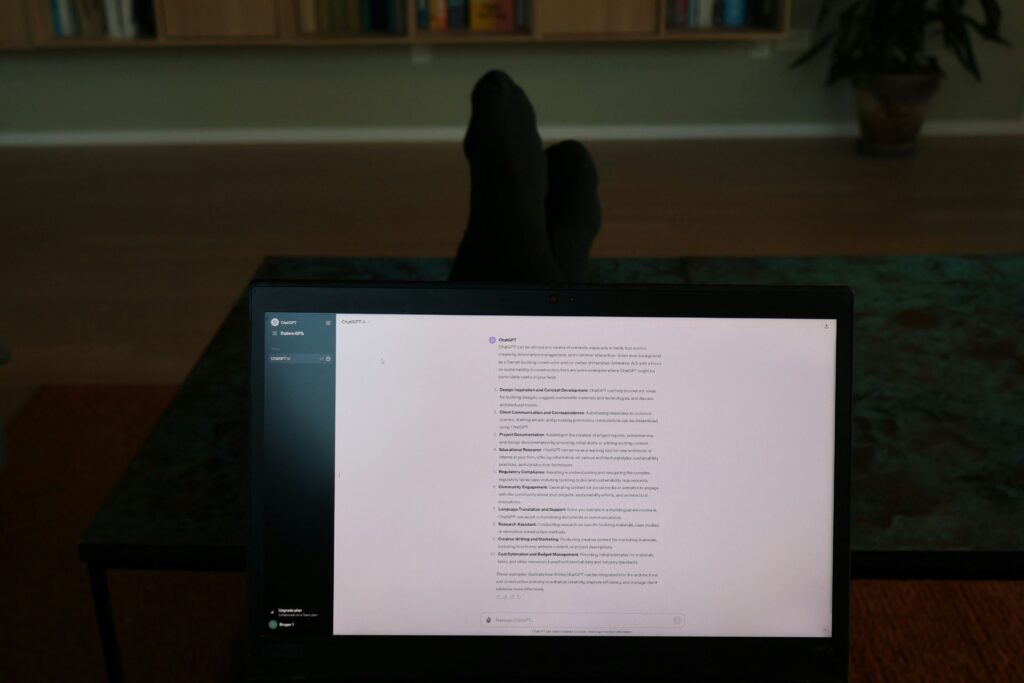 A laptop screen resting on a person's legs.