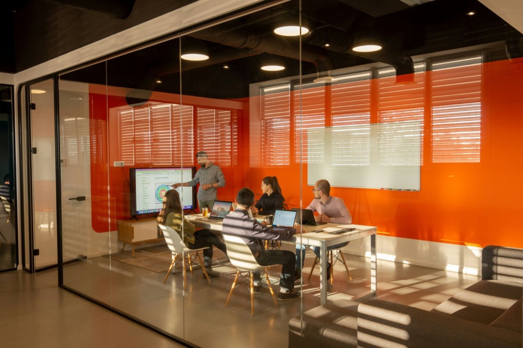 Colleagues gathered around a table for a discussion in an office setting.