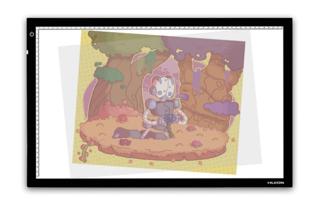 A Huion tracing light box displaying a colorful illustration of a whimsical forest scene with a character sitting on a log.