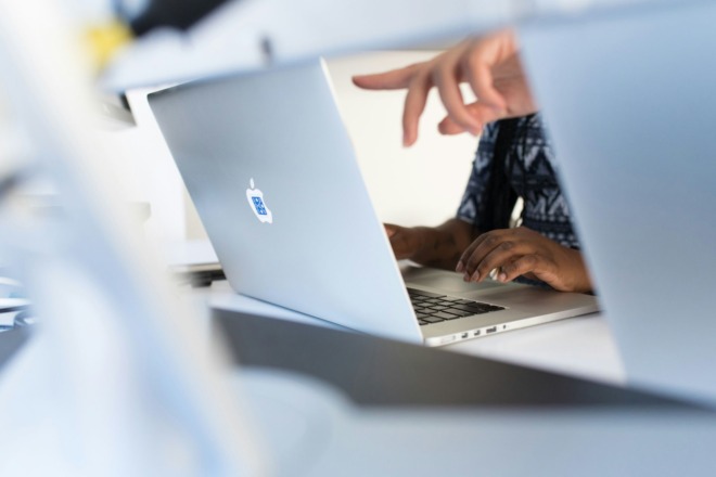 Two people working on a laptop.