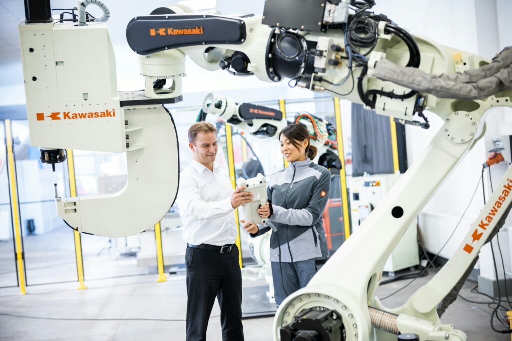 Man and woman standing in front of a robot
