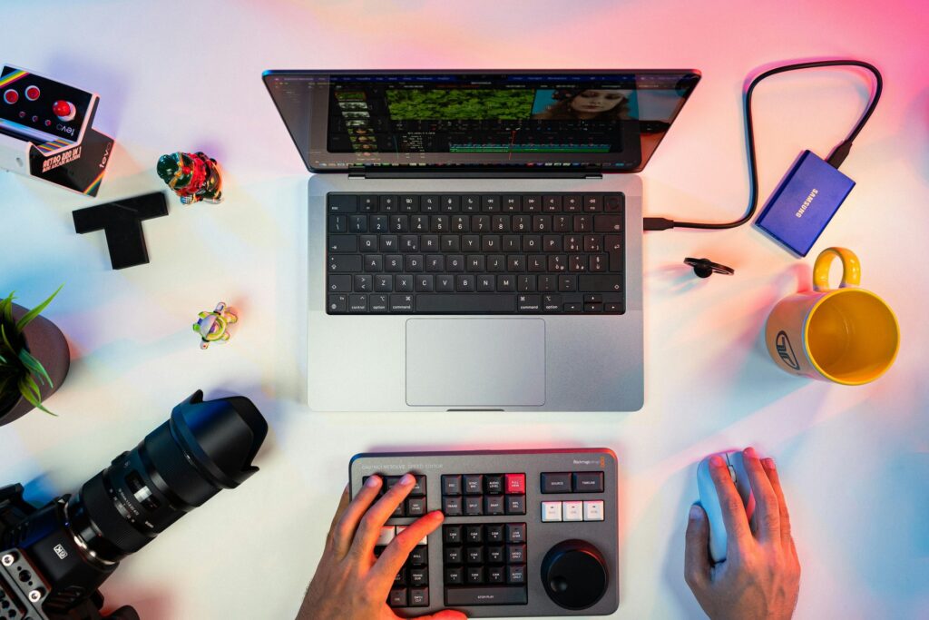top view of a laptop, camera and other photo editing gadgets